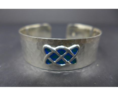 A Celtic style white metal and enamel bangle 