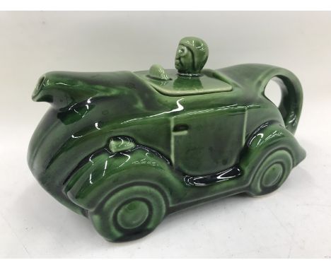 A green glazed ceramic teapot in the form of a car.