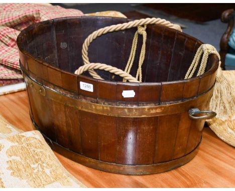 A staved ovoid formed planter with brass carry handles, 67cm by 54cm by 28cm