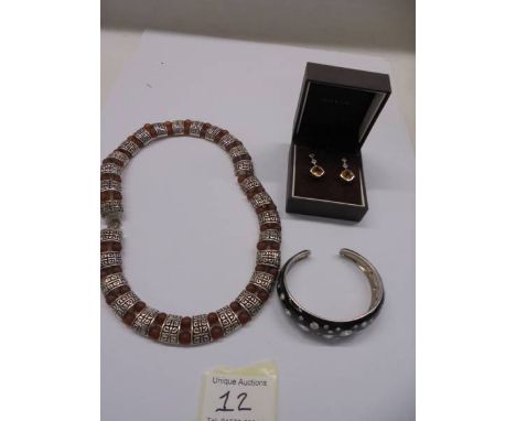 A silver bangle set with white stones, a vintage necklace and a pair of silver stone set earrings.