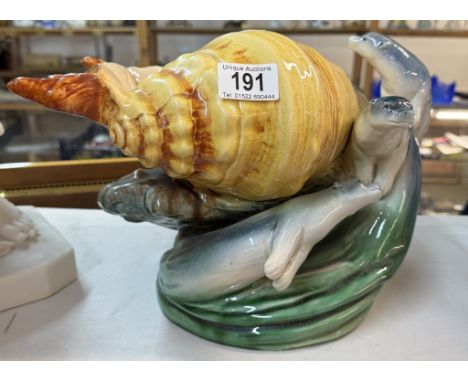 A large continental ceramic table centrepiece of a shell with 3 sea lions