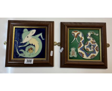 A pair of framed decorative ceramic tiles