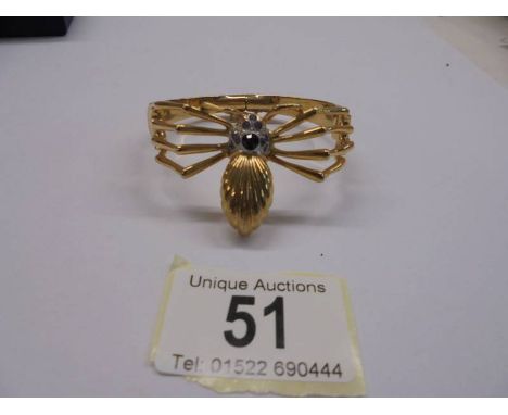 A yellow metal bangle fashioned as a spider,.