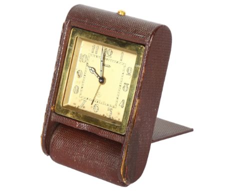 A Jaeger travelling alarm clock with 8-day movement, in snakeskin folding case, overall dial width 5.5cmCase has some tears a