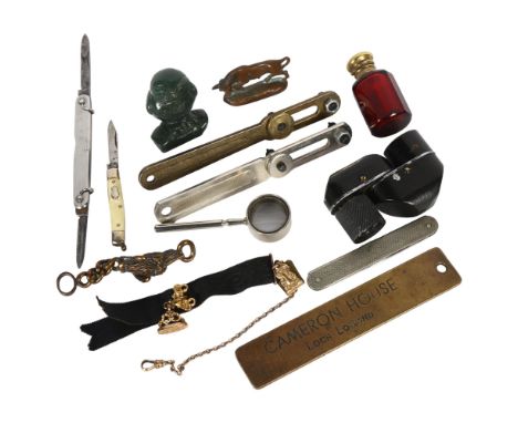 A group of interesting items, including a small carved green stone owl, 2 wristwatch tools, miniature magnifying glass, dog f