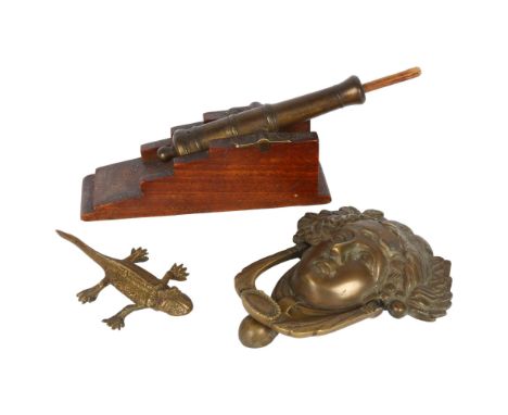 A brass table cannon with ramrod, a brass lizard, and a cast-brass door knocker (Medussa) 