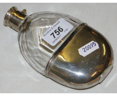 A glass and silver oval hip flask with engraved crest.