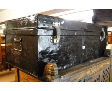 A black painted metal trunk with carrying handles.
