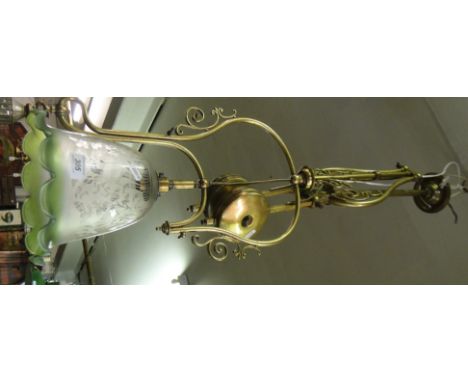 A rise and fall brass lamp with floral decorated shade.