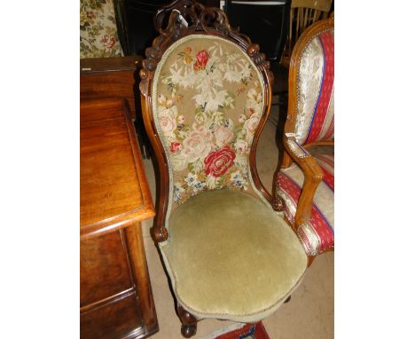 A 19th century carved mahogany framed nursing chair with tapestry upholstery.