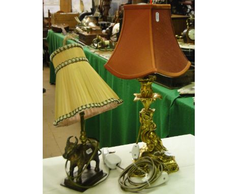 A gilt brass table lamp with cherub support and an Eastern brass table lamp with cow figure.