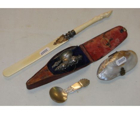 A mother of pearl purse, an ivory paper knife, cased manicure items and a caddy spoon.