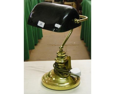 Adjustable brass desk lamp with green shade.