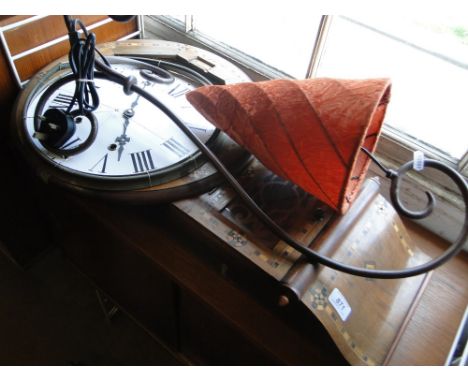 A Victorian walnut and marquetry decorated drop dial wall clock and a scrolled metal table lamp with cone shade.