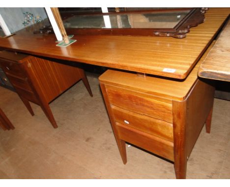 A Vintage teak writing desk, the two pedestals fitted with 6 short drawers bearing label for Carsons Office Furniture.