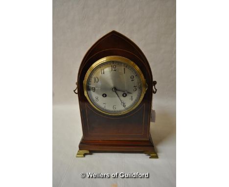 A late 19th Century mahogany mantel clock with arched top, boxwood stringing, the silvered dial  with Arabic numerals, the tw