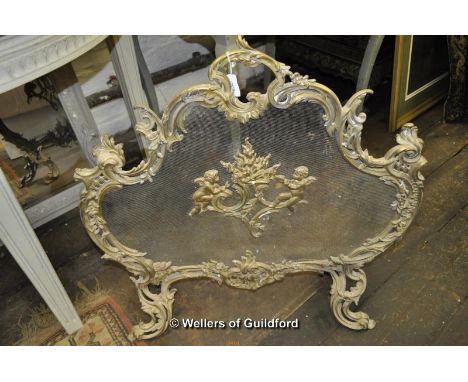 A Roccoco style brass firescreen on scrolling feet.