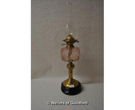 *A Victorian brass oil lamp with pink glass reservoir, 66cm including chimney. (Lot subject to VAT)