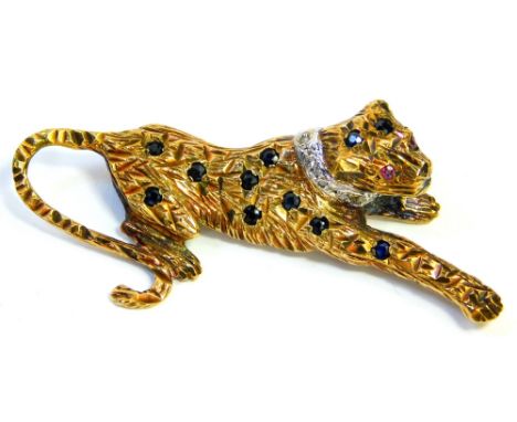 A 9ct gold leopard brooch, the body set with various sapphires, with a tiny diamond set white gold collar and ruby eyes, 5cm 