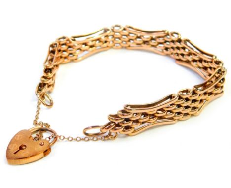 A 9ct rose gold gate bracelet, of multi curb link design, with outer elongated bent in borders, with a 9ct gold heart shaped 