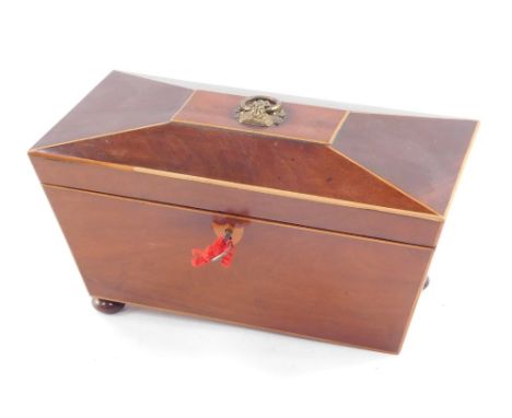 A Georgian mahogany and boxwood inlaid tea caddy, of sarcophagus form, the lid opening to reveal a central recess flanked by 