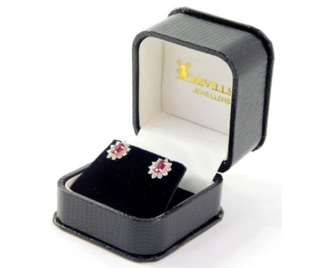 A pair of 18ct gold ruby and diamond oval flower head earrings, cased and outer boxed.