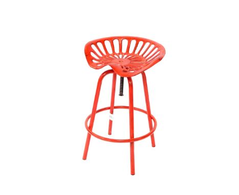 An Esschert Design red metal revolving chair, with tractor form seat, raised on four curved leg united by a hoop frame, 71.5c