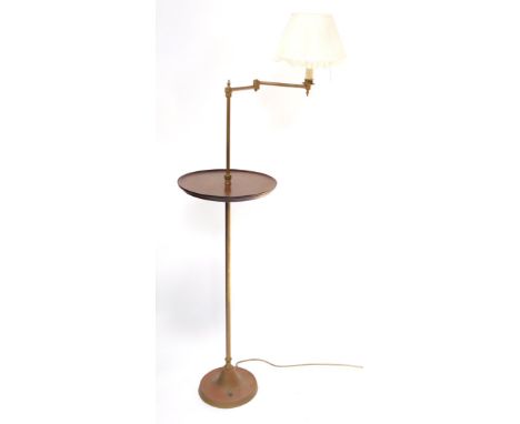 A brass and mahogany standard lamp table, the lamp with an angular arm and cream shade, above a circular table, raised on a b