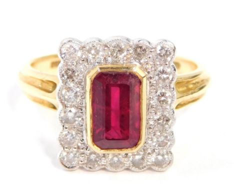 An 18ct gold ruby and diamond dress ring, with rectangular cut, central ruby in rub over yellow gold setting, surrounded by t