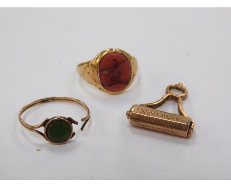 A carnelian crested signet ring, set in yellow metal, size K, further ring, and a roller seal, with engraved named detailing,