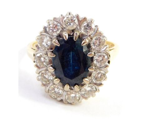 A sapphire and diamond set dress ring, the central oval sapphire in a claw setting, 9.2mm x 6.6mm x 4.8mm, surrounded by twel