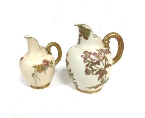 A Royal Worcester caneware jug decorated with floral handpainted sprays, with gilt handles and another similar smaller (2) (1