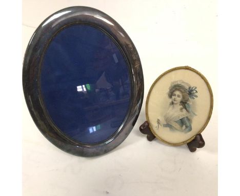 An Epns oval photograph frame (22cm x 17cm) on easel stand and an Edwardian oval brass mounted portrait miniature, after Sir 