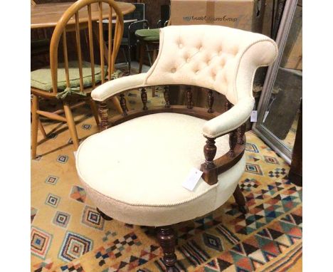 An Edwardian horseshoe shaped button back, upholstered arm and seat tub chair, raised on turned tapered supports (69cm x 58cm