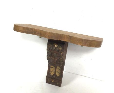 An oak wall bracket with serpentine moulded top above an earlier giltwood carved oak lion mask (25cm x 33cm x 15cm)