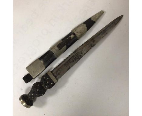 An early 20thc Scottish piper's dirk, carved ebonised handle with plain pommel, scabbard with white metal thistle engraved mo