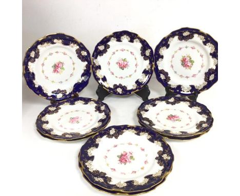 A set of eight Royal Crown Derby porcelain plates decorated with central floral panels enclosed within floral ring, with gilt