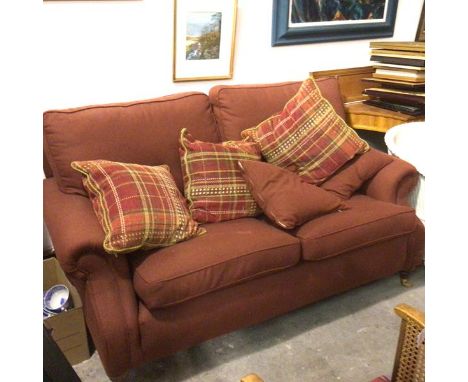 A modern two seater sofa with walnut frame upholstered in terracotta tweed style fabric, complete with squab and scatter cush