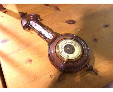 An Edwardian walnut aneroid wall barometer complete with thermometer, with enamelled dial (56cm x 22cm)