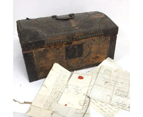 An 18thc leather and copper studded and cast iron cornered travelling dome top trunk, with brass swan neck handle to top, con