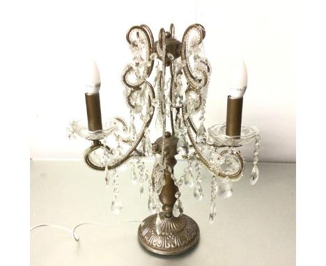 A Continental white and gilt metal three branch baluster stem table candelabra table lamp with faceted drops, on circular bas