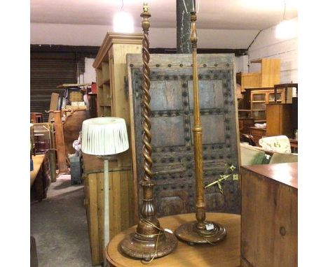 An oak spiral twist column floor lamp raised on circular moulded base and an oak fluted tapered column floor lamp on circular