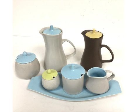 A Poole pottery set c.1960 including two hot milk jugs, a sugar basin, a jam pot, a miniature sugar basin and milk jug on sta