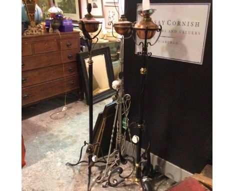 Two wrought iron and brass mounted and copper Art Nouveau style adjustable column oil lamps, converted to electricity, on tri