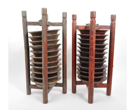 A pair of wooden Chinese plate stacking caddy racks operated by releasing one of the wooden legs to access the plates. Measur