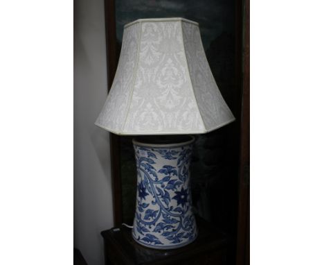 A LARGE BLUE AND WHITE TABLE LAMP of cylindrical waisted form decorated all over with trailing foliate design together with a