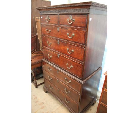 A GEORGE III OAK TALLBOY with blind fretwork decoration to the cornice and mahogany cross banding to the two short and six lo