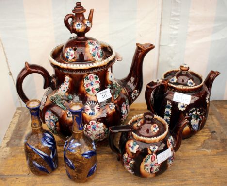 A LARGE VICTORIAN BARGEWARE TEAPOT 34cm high together with two smaller Bargeware teapots, one inscribed 'God Bless Our Home',