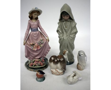 A LLADRO PORCELAIN FIGURE of a girl holding flowers in the folds of her dress, 25cm high, together with a Nao figure of a boy