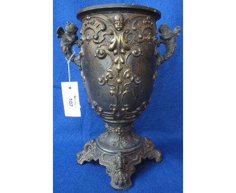 Cast metal, gilded relief decorated pedestal urn in Classical style with cherub mounts, possibly originally an oil lamp base.